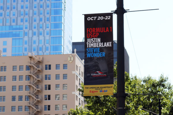 Banner saver brackets and custom banners advertising an event on a street light.