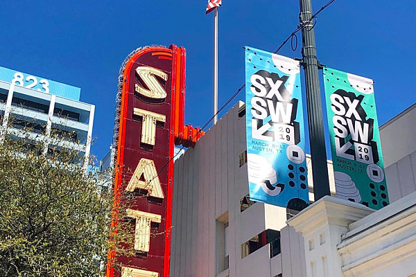 Banner Saver bracket system holding custom banners outside of an iconic theater in Austin, Texas.
